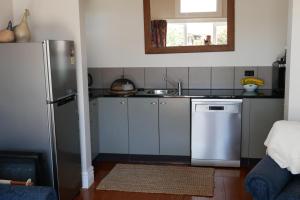 a kitchen with a refrigerator and a sink at Havelock Cottage on St Georges in Havelock North