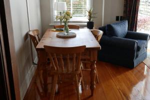 - une table à manger avec des chaises et un canapé dans l'établissement Havelock Cottage on St Georges, à Havelock North 6 autres photos