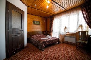 1 dormitorio con cama, ventana y puerta en Karpatska Vezha en Migovo