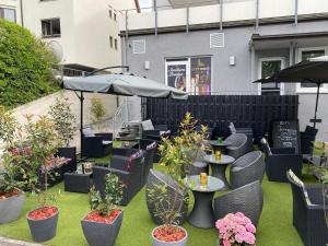 a patio with tables and chairs with plants and umbrellas at City Vibes Hotel in Sindelfingen +5 photos