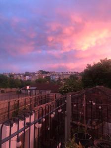 a view of a sunset from a balcony with a fence at The Cottage, Ashfield Place in Bristol