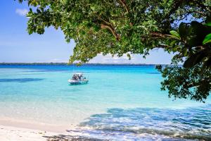 a boat in the water on a beach at Barrier Beach Resort in Luganville