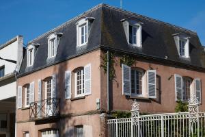 un bâtiment avec des fenêtres blanches et un toit noir dans l'établissement Les Toits de Chartres - 2 appt - Parking gratuit, à Chartres