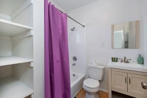 La salle de bains est pourvue d'un rideau de douche violet et de toilettes. dans l'établissement Los Angeles Retreat Close to Hotspots, à Los Angeles