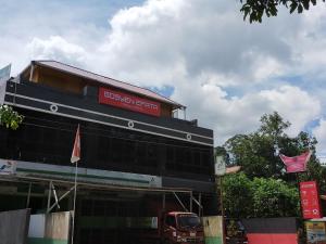 een gebouw met een rood bord erop bij Gosyen Efata Toraja Hotel in Makale