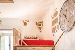 a room with a bed and a wall with a fan at Tipica casa a San Pantaleo in San Pantaleo
