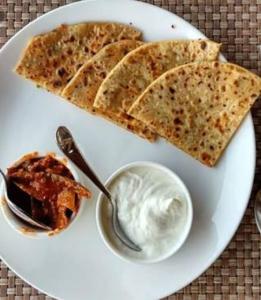 un plato blanco con un plato de comida en una mesa en HOTEL SILVER PALM, en Zirakpur