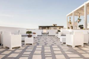 a row of white chairs on a rooftop patio at Faro Bianco Gallipoli Dependance in Gallipoli