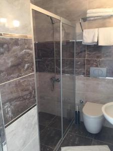 uma casa de banho com um chuveiro e um WC. em VERDE PORT HOTEL em Fethiye