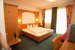 リート・イム・ツィラータールにあるFerienhof Lacknerのベッドと鏡が備わるホテルルーム