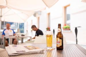 eine Flasche Bier auf einem Tisch mit einer Zeitung in der Unterkunft BB Garni Motta in Airolo
