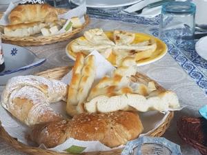 a table topped with plates of bread and pastries at SUITE-Junior -Villa HÉLÈNE - Montpellier Sud - aéroport- PISCINE Privée-2mn des plages in Pérols