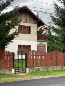 a house with a red fence in front of it at Vila Busteni DORA, locatie superba strada Grivitei 36 in Buşteni +6 photos