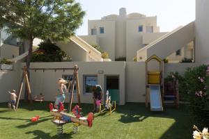 um grupo de pessoas brincando em um playground em um quintal em The Majestic Hotel em Fira