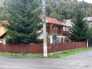 une maison avec une clôture rouge devant elle dans l'établissement Vila Busteni DORA, locatie superba strada Grivitei 36, à Buşteni