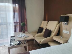 une pièce avec deux chaises, une table et un lit dans l'établissement LUNA-Guest Rooms, à Alcalá de Guadaira