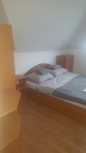 sypialnia z łóżkiem z drewnianym zagłówkiem w obiekcie Bliss apartment w mieście Tata