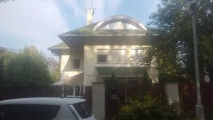 biały dom z zaparkowanym przed nim samochodem w obiekcie Bliss apartment w mieście Tata