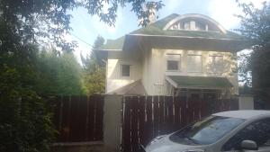 Biały dom z płotem i samochodem z przodu w obiekcie Bliss apartment w mieście Tata