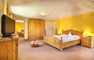 a bedroom with a large bed and a flat screen tv at Zedernhof Gesundheits- & Wellnesshotel in Stamsried