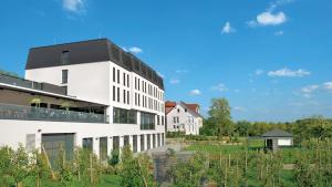 a white building with a black roof at Landhotel Beck in Kupferzell