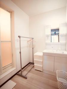 a white bathroom with a white sink and a desk at Tomoeドットコム2 onepiecehouse in Hakodate