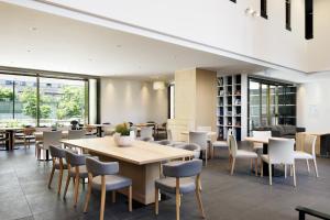 - une salle à manger avec des tables, des chaises et des fenêtres dans l'établissement Fairfield by Marriott Sapporo, à Sapporo