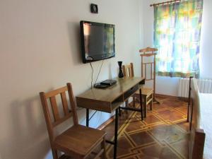 a dining room with a table and a tv on the wall at Home with the veranda (B&B) free parking in Veliko Tŭrnovo