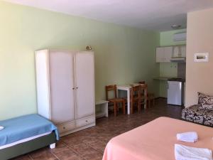a room with a bed, table and a refrigerator at Epis Hotel in Agia Marina Nea Kydonias