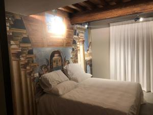 a bedroom with a large bed with a painting on the wall at Villa Cantoni Marca in Sabbioneta
