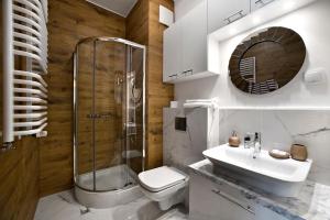 y baño con aseo, lavabo y ducha. en Prymasa Tysiaclecia - P&O Serviced Apartments, en Varsovia