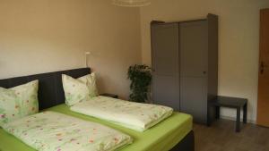 a bedroom with two beds and a table and a cabinet at Ferienwohnung Schruttke in Bad Frankenhausen