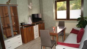 a living room with a desk and a table with a tv at Ferienwohnung Schruttke in Bad Frankenhausen