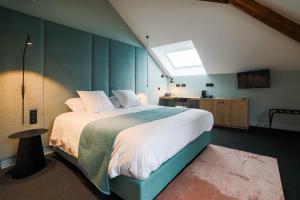 a bedroom with a large bed with a green wall at Hôtel Vedette in Profondeville