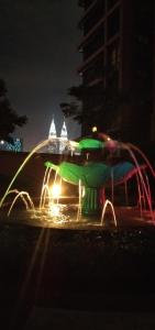 a water fountain at night in a city at KL Short & Long Stay Suites At Times Square in Kuala Lumpur