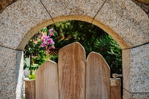 uma cerca de madeira em frente a um arco em Relais Villa Carola em Porto Cervo