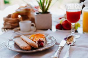 a plate of breakfast food on a table with a drink at Relais Villa Carola in Porto Cervo