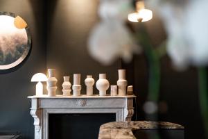 a fireplace with white candles on top of it at Hôtel Vedette in Profondeville