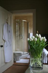 a bathroom with a shower and a toilet and a vase of flowers at Alexandra Court in Harrogate
