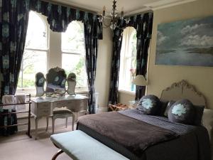 1 dormitorio con 1 cama, escritorio y ventanas en Alexandra Court en Harrogate