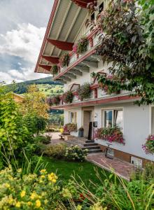 a house with flowers on the side of it at Appartements-Pension Lindenheim in Schladming