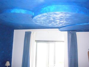 a room with a blue ceiling and a window at La Rosa dei Venti Resort in Piombino