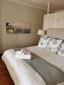 a bedroom with a bed with a towel on it at The Hamptons Guest House in Durban