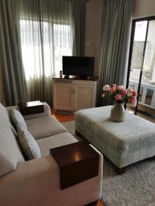 a living room with a couch and a vase of flowers at The Hamptons Guest House in Durban