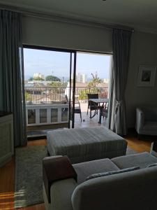 a bedroom with two beds and a view of a balcony at The Hamptons Guest House in Durban