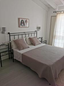 a bedroom with a large bed and a window at Affittacamere Alisso in Olbia