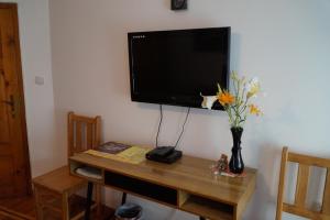 una mesa con TV y un jarrón con flores. en Home with the veranda (B&B) free parking en Veliko Tŭrnovo