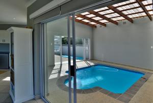 a swimming pool in a house with a glass extension at Cannon House in Cannon Rocks