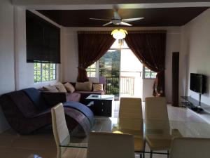 a living room with a table and a couch at Cameron Pasar Malam Apartment @ Crown Imperial Court in Cameron Highlands