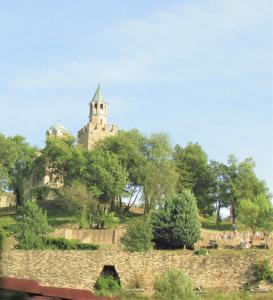 a castle on top of a hill with trees at Home with the veranda (B&B) free parking in Veliko Tŭrnovo